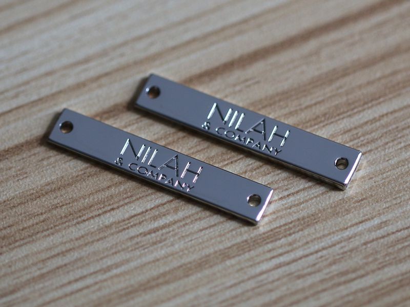 nhận làm tem mác kim loại cho quần áo, túi xách, thời trang